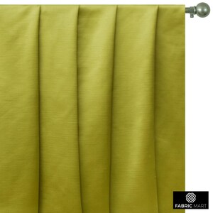 May include: A close-up of a green curtain with pleats. The curtain is made of a smooth, silky fabric.