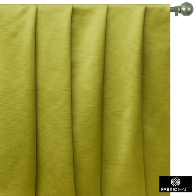 May include: A close-up of a green curtain with pleats. The curtain is made of a smooth, silky fabric.