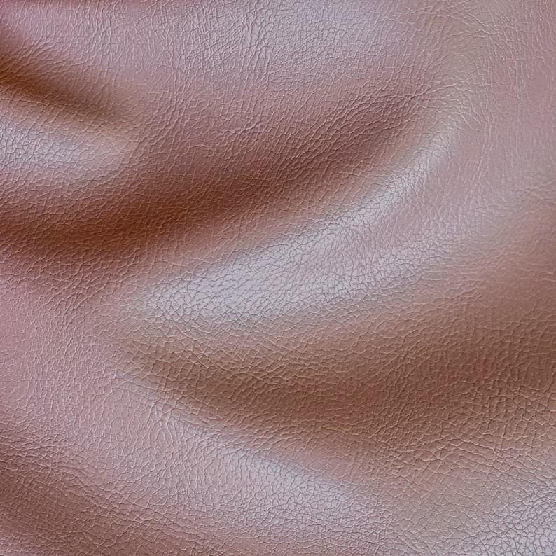 May include: Close-up of a brown leather texture with a subtle sheen. The leather has a pebbled surface and is slightly wrinkled, creating a soft and inviting look.