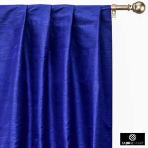 May include: Royal blue silk curtains with pleats hanging from a curtain rod.