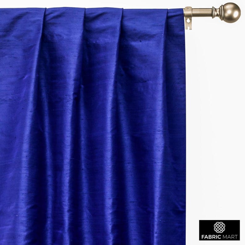 May include: Royal blue silk curtains with pleats hanging from a curtain rod.