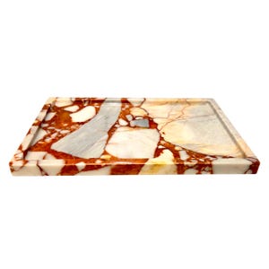 May include: Rectangular marble tray with a raised edge. The tray features a unique pattern of red, white, gray, and yellow hues. The tray is made of stone and is suitable for decorative or functional use.
