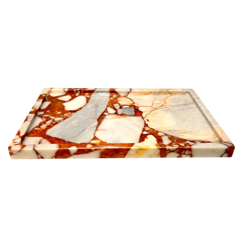 May include: Rectangular marble tray with a raised edge. The tray features a unique pattern of red, white, gray, and yellow hues. The tray is made of stone and is suitable for decorative or functional use.