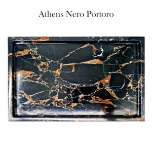 Puede incluir: Bandeja rectangular de m&aacute;rmol negro con vetas doradas y blancas. La bandeja tiene un borde elevado y el texto "Athens Nero Portoro" en la parte superior. El m&aacute;rmol tiene un acabado pulido, mostrando los patrones y colores naturales.