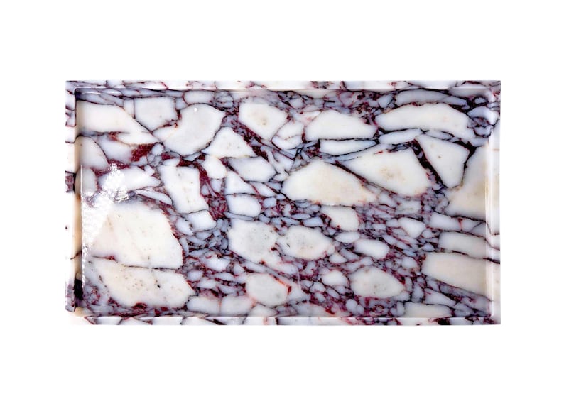 May include: Rectangular tray with a marble design. The tray features a pattern of white and burgundy-coloured stone fragments, creating a mosaic effect. The edges of the tray are smooth and polished.