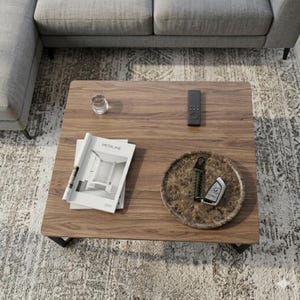 Puede incluir: Una mesa de centro cuadrada de madera oscura con un vaso de agua, un mando a distancia, una revista con la palabra "MEDICINE" y una bandeja decorativa con llaves. La mesa est&aacute; sobre una alfombra estampada.