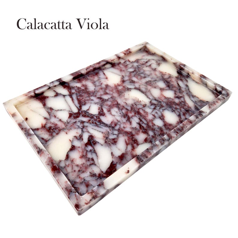 Puede incluir: Una bandeja rectangular con dise&ntilde;o Calacatta Viola. La bandeja presenta un patr&oacute;n de vetas blancas y moradas rojizas profundas, creando un efecto marmolado. Los bordes est&aacute;n ligeramente elevados y la bandeja est&aacute; sobre un fondo blanco.