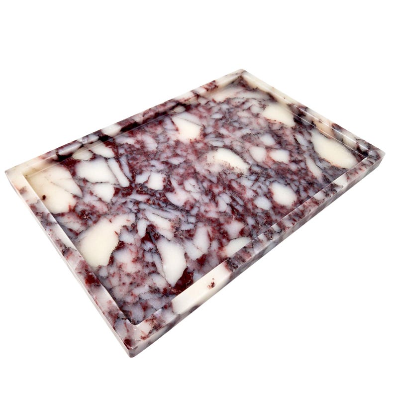 May include: Rectangular tray with a marbled design. The tray features a mix of white and burgundy colors, creating a unique pattern. The tray has a raised edge and a glossy finish, suitable for decorative or functional use.