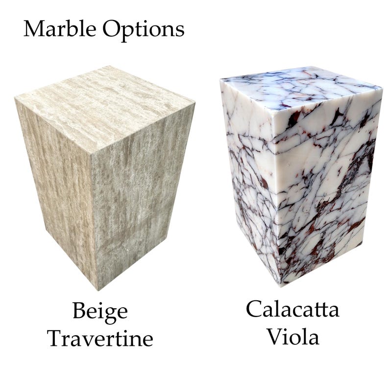 May include: Two marble blocks with the text "Marble Options". The block on the left is beige travertine. The block on the right is Calacatta Viola marble with purple veining.