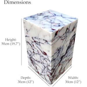 May include: A white marble cube with dark red and gray veining. The dimensions are: height 19.7 inches, depth 12 inches, and width 12 inches. The text "Dimensions" is at the top.