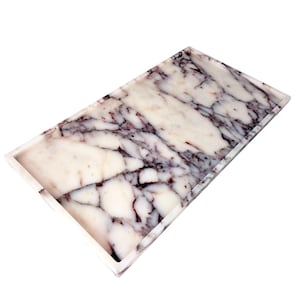 May include: Rectangular marble tray with a white base and dark purple veining. The tray has a raised edge and a polished finish. This decorative tray can be used for serving or as a decorative accent.
