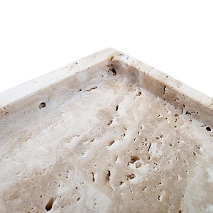May include: Close-up of a rectangular, beige-colored tray with a textured surface. The tray has a porous, stone-like appearance with small holes and variations in color. The corner of the tray is visible against a white background.