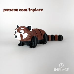 Peut inclure: Figurine de panda roux imprimée en 3D, avec un corps marron, des pattes noires et un visage blanc. La figurine a de grands yeux et une queue touffue. Le texte "patreon.com/inplace" est en haut et "INPLACE" en bas.