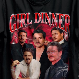 Puede incluir: Camiseta negra con un gráfico de varios hombres y el texto "GIRL DINNER" en rojo. La camiseta también tiene el logo "STITCH AURA" y una oferta promocional para compras al por mayor.