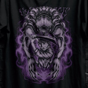 May include: Black t-shirt featuring a graphic of a person fighting a monster, surrounded by purple energy. The shirt has the text "STITCH AURA" and promotional text for bulk purchases.
