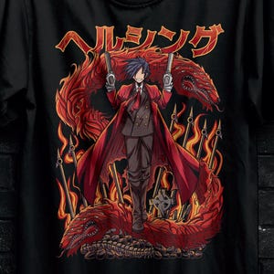 Può includere: T-shirt nera con un'illustrazione in stile anime di un personaggio con pistole, un drago rosso e fiamme. Il testo giapponese "ヘルシング" è sopra il personaggio. La maglietta è appesa a una gruccia nera.