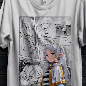 Può includere: T-shirt bianco con grafica in stile manga raffigurante un personaggio femminile in un design a fumetti. La maglietta ha girocollo e maniche corte. La maglietta è appesa a una gruccia nera.