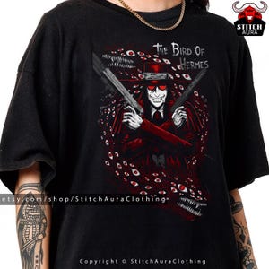 May include: Black t-shirt featuring a red and white illustration of a character from "The Bird of Hermes" anime. The character is holding two guns and surrounded by red eyes. The shirt has the text "The Bird of Hermes".