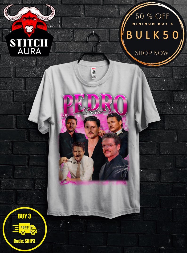 May include: A white t-shirt featuring a graphic of Pedro Pascal in various poses, with the name "PEDRO" in pink text. The shirt also has the text "STITCH AURA", "BUY 3 FREE", and "BULK50".