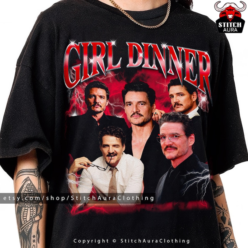 Może przedstawiać: Czarna koszulka z grafiką z napisem "GIRL DINNER" w kolorze czerwonym, z kolażem zdjęć mężczyzny. Projekt jest osadzony na czerwono-czarnym tle z błyskawicami. Widoczna jest nazwa sklepu Etsy.