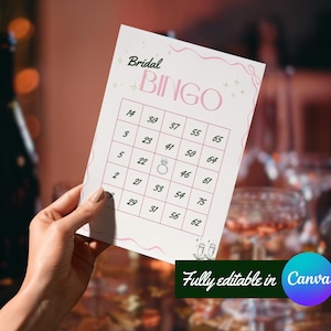 Peut inclure: Une carte de Bingo de mariage avec un design rose et blanc. La carte présente une grille de chiffres et le mot "BINGO" en rose. La carte est tenue par une main, avec un arrière-plan flou de verres à champagne.
