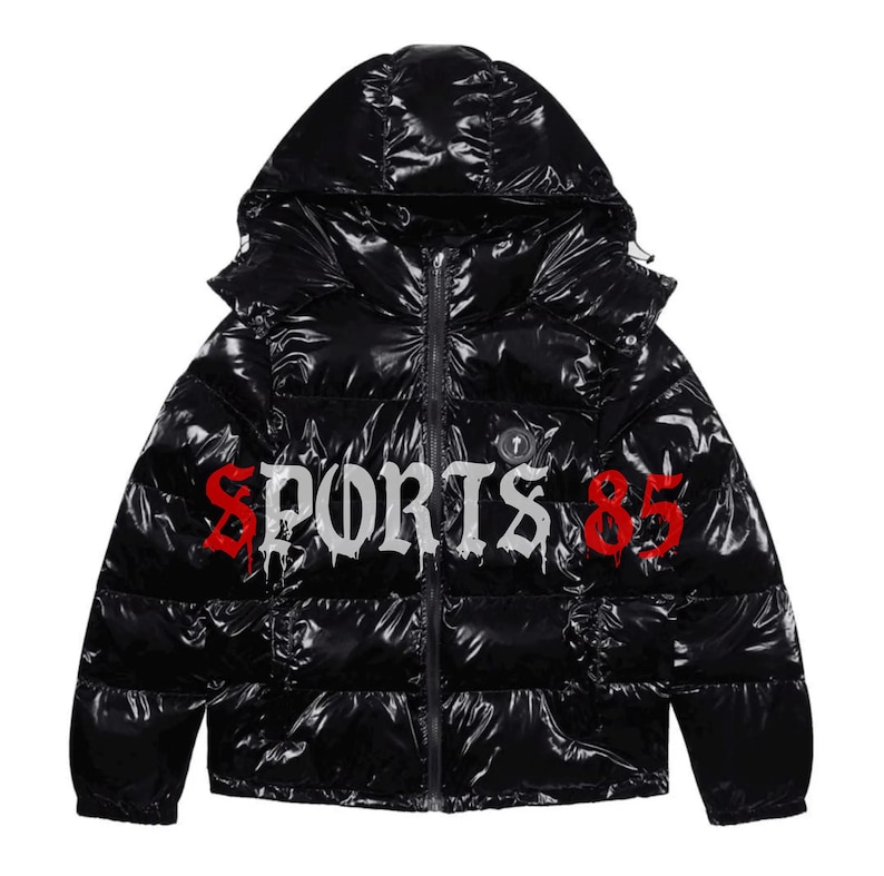 Pode incluir: Casaco puffer preto com capuz e acabamento brilhante. O casaco apresenta a palavra "SPORTS" em letras g&oacute;ticas brancas e o n&uacute;mero "85" em vermelho. Possui um z&iacute;per de comprimento total e um design acolchoado.