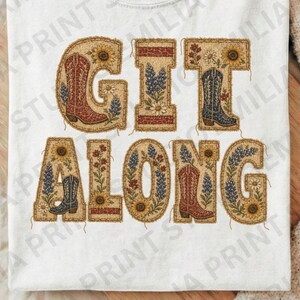 Könnte beinhalten: Ein weißes T-Shirt mit dem Schriftzug GIT ALONG in großen Blockbuchstaben. Jeder Buchstabe ist mit einem strukturierten, beigefarbenen Muster gefüllt, das mit Illustrationen von bunten Cowboystiefeln, Sonnenblumen und blauen Wildblumen verziert ist.
