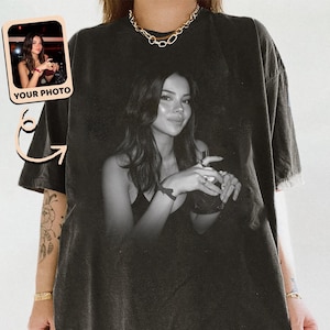 May include: Black oversized t-shirt featuring a black and white photo of a person holding a drink. A smaller image with the text "YOUR PHOTO" is in the upper left corner. The shirt has a worn, vintage look.