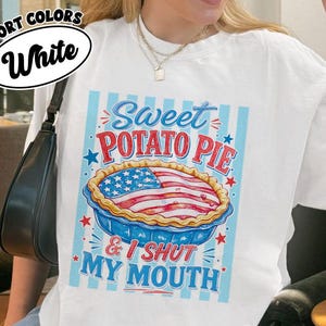 Könnte beinhalten: Ein weißes T-Shirt mit einer Grafik eines Kuchens, dessen Kruste wie die amerikanische Flagge gemustert ist. Der Text Sweet Potato Pie & I Shut My Mouth steht in roter und blauer Schrift vor einem Hintergrund aus hellblauen Streifen.