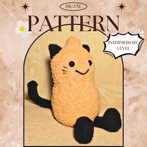 Puede incluir: Un juguete de peluche con forma de gato con cuerpo naranja claro, orejas, cola y patas negras. El juguete tiene una cara sonriente con ojos y bigotes negros. Incluye el texto "DIGITAL PATTERN" y "INTERMEDIATE LEVEL".