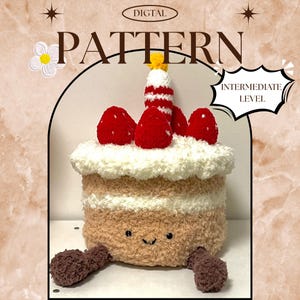 May include: A crocheted cake with a smiling face, red strawberry decorations, and a candle. The cake is tan with white frosting and a brown base. The text "DIGITAL PATTERN" and "INTERMEDIATE LEVEL" are also visible.
