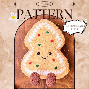 Puede incluir: Un patrón de hombre de jengibre tejido a ganchillo con el texto "DIGITAL PATTERN" y "INTERMEDIATE LEVEL". El hombre de jengibre es de color canela con glaseado blanco, chispas rojas y verdes y pies marrones. El fondo es una superficie de madera.