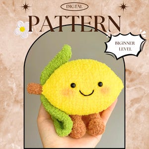 May include: A plush lemon toy with a smiling face, green leaf, and brown feet. The text "DIGITAL PATTERN" and "BEGINNER LEVEL" are visible. The toy is held in a hand against a beige background.