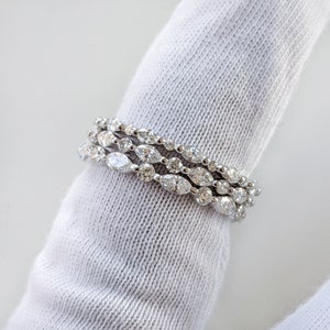 May include: A set of three silver rings with a row of marquise-shaped diamonds on each band.