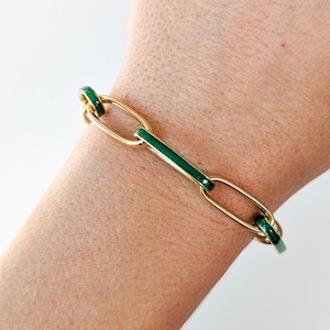 Peut inclure: Un bracelet en cha&icirc;ne dor&eacute;e avec des accents d'&eacute;mail vert. Le bracelet est compos&eacute; de maillons ovales et rectangulaires.