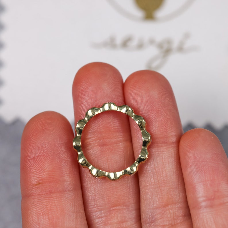 May include: A gold ring with a textured, scalloped edge.