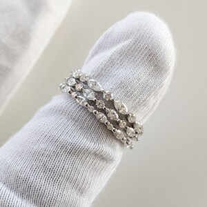 May include: Four silver rings with a row of small round diamonds and a row of larger oval diamonds.