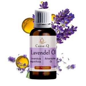 Könnte beinhalten: Eine braune Glasflasche Lavendelöl mit weißem Verschluss, beschriftet mit "Casse-Q Lavendel Öl". Die Flasche ist von lila Lavendelzweigen und goldenen Öltropfen umgeben. Das Etikett trägt auch die Aufschrift "100% Naturrein" und "10ml".