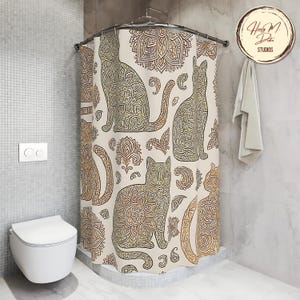 May include: A beige shower curtain featuring a repeating pattern of stylized cats and floral designs in shades of brown and gold. The cats are intricately detailed with mandala-like patterns. The curtain is hanging in a bathroom setting.