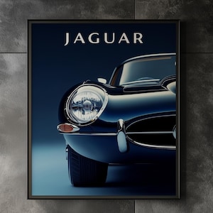 Puede incluir: Impresión enmarcada que presenta un coche Jaguar clásico en azul marino. La parte delantera del coche, incluyendo un faro y la palabra "JAGUAR" en blanco, se muestra sobre un fondo azul oscuro. La impresión está en un marco negro.