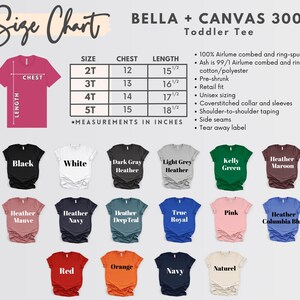 May include: A size chart for toddler tees, with measurements in inches. The chart includes chest and length measurements for sizes 2T to 5T. The image also displays various t-shirt colors, including black, white, red, and navy. The brand is Bella + Canvas.