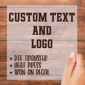 May include: Image featuring the words "CUSTOM TEXT AND LOGO" in a bold, brown font. Below, bullet points list "DTF TRANSFER," "HEAT PRESS," and "IRON ON DECAL." The background is a light brown wood grain.