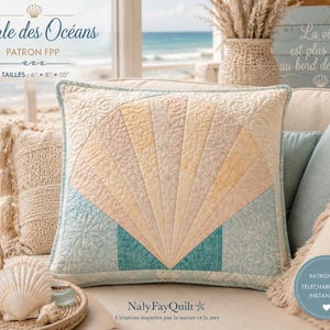 May include: A decorative square pillow with a fan-shaped design in pastel colors of blue, peach, and yellow. The pillow has a light blue border and is part of a collection inspired by the sea. The text "Perle des Océans" is at the top.