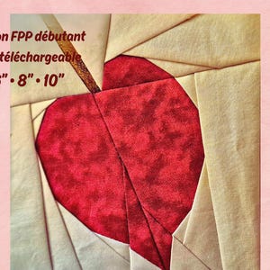 Peut inclure: Une pièce d'art textile représentant un cœur rouge avec une tige marron, sur un fond de tissu beige et crème. Le texte "Patron FPP débutant PDF téléchargeable 6" • 8" • 10"" est visible dans le coin supérieur gauche.