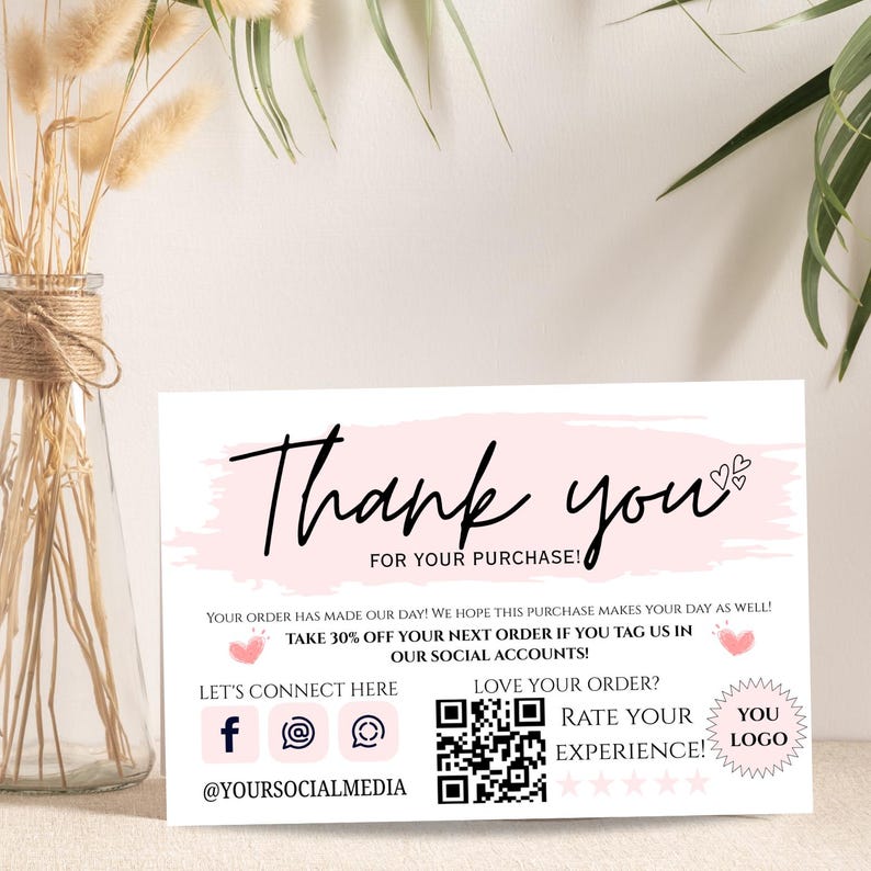 Pu&ograve; includere: Biglietto di ringraziamento bianco con un design a pennellate rosa. La carta presenta le parole "Thank you" in elegante scrittura, insieme a testo aggiuntivo e icone dei social media. Sono inclusi anche un codice QR e spazio per un logo.