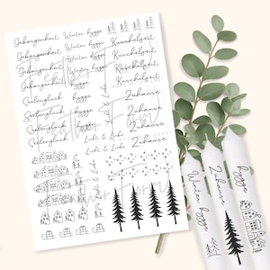 May include: A collection of white candles and a sheet of paper with black illustrations and text. The paper features words like "Geborgenheit", "Winter hygge", and "Kuschelzeit", along with drawings of houses, trees, and stars. The candles have similar text and drawings.