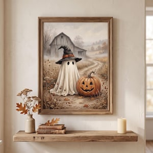 Puede incluir: Una l&aacute;mina de arte enmarcada que representa a un fantasma blanco con un sombrero de bruja negro junto a una calabaza naranja tallada en un camino de tierra frente a un granero de madera r&uacute;stico en un campo con follaje oto&ntilde;al.