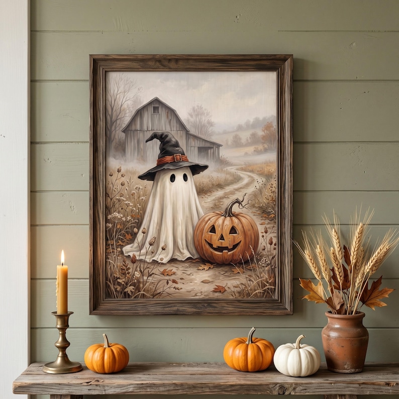 Puede incluir: Una l&aacute;mina de arte enmarcada que muestra un fantasma blanco con un sombrero de bruja negro junto a una calabaza tallada de color naranja en un camino de tierra. Al fondo, un granero de madera r&uacute;stico se alza en un campo brumoso.