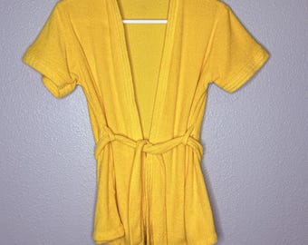 Bata corta de felpa amarilla vintage de los años 70 con cinturón, ideal para spa o sala de estar. Talla S/M.