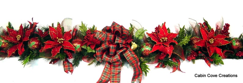 May include: A red and green Christmas garland with poinsettia flowers, red berries, and a plaid bow. The garland is decorated with gold glitter and is perfect for adding a festive touch to any home.